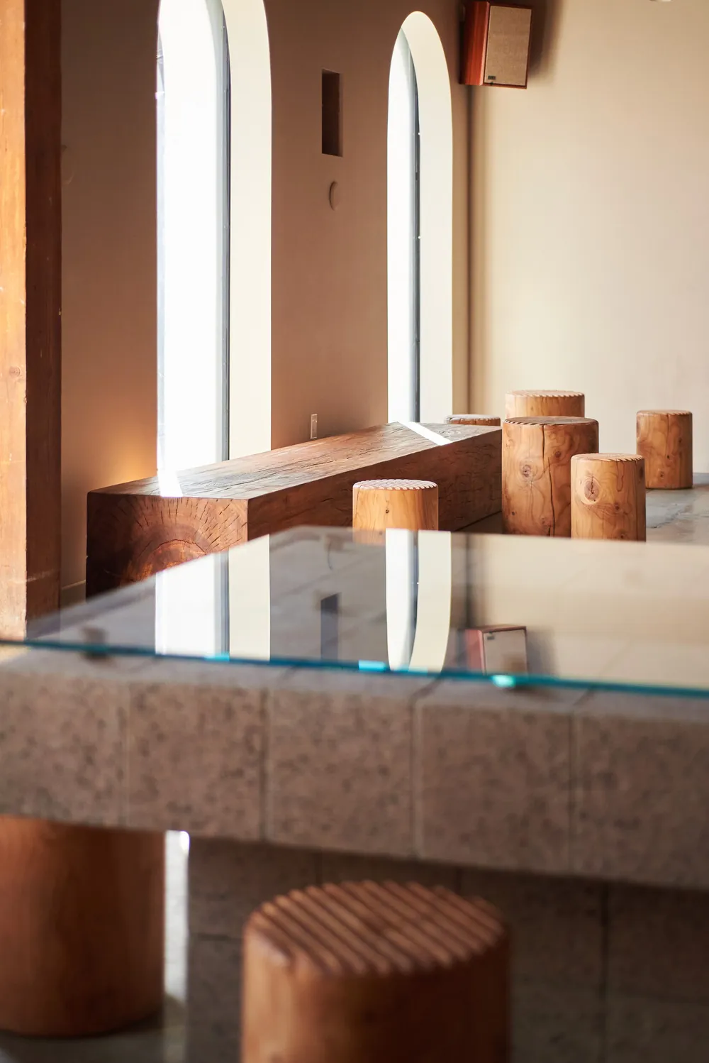 The glass-topped table under the arched windows